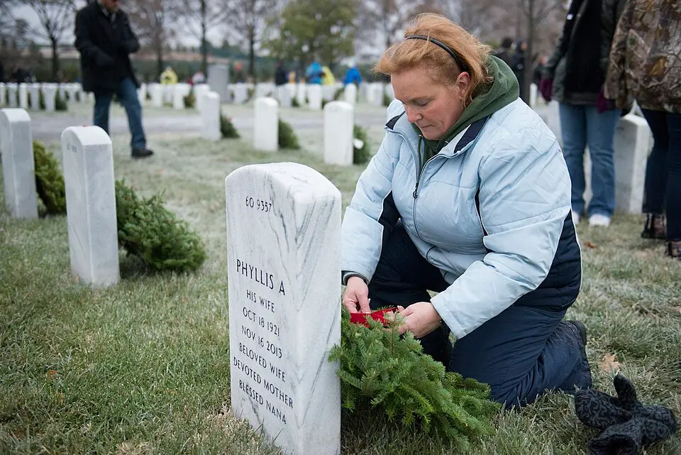 Remembrance wreaths on headstones at Arlington National Cemetery during National Wreaths Across America Day.